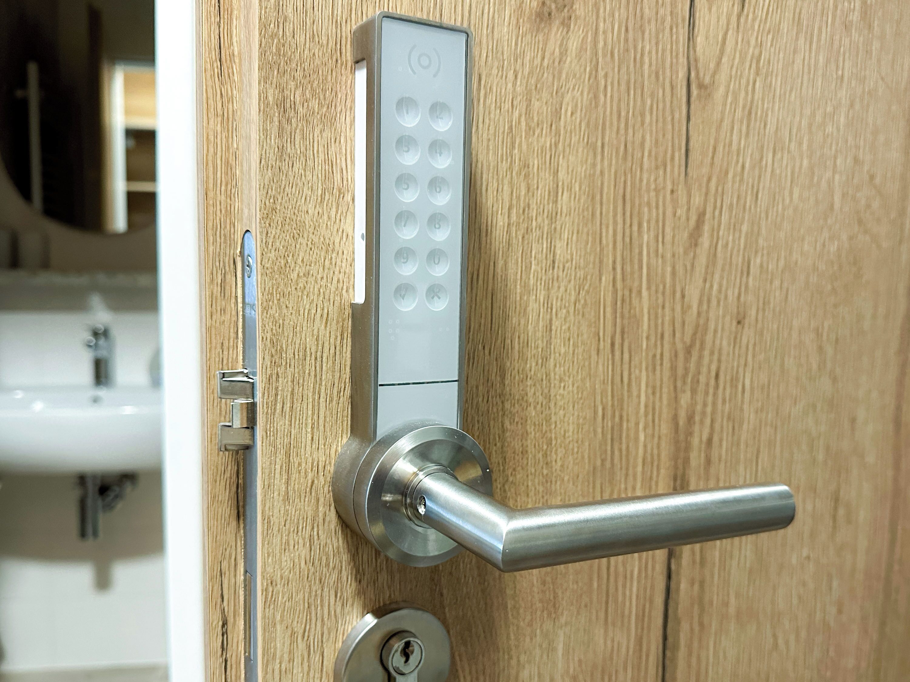 Una puerta moderna con sistema de entrada sin llave y un tirador metálico.