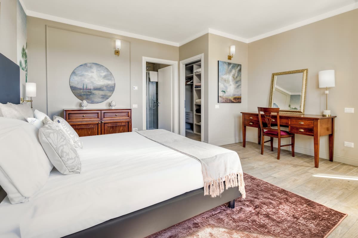 Une chambre à coucher comprenant un lit, un bureau, une chaise, une armoire et une salle de bain.