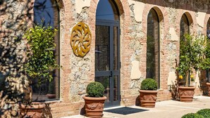 A building with arched windows, a central door, and decorative elements. - Guild Living Siena Senior Resort & Residence (Siena)