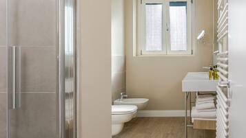 Une salle de bain avec des toilettes, un bidet et une fenêtre.