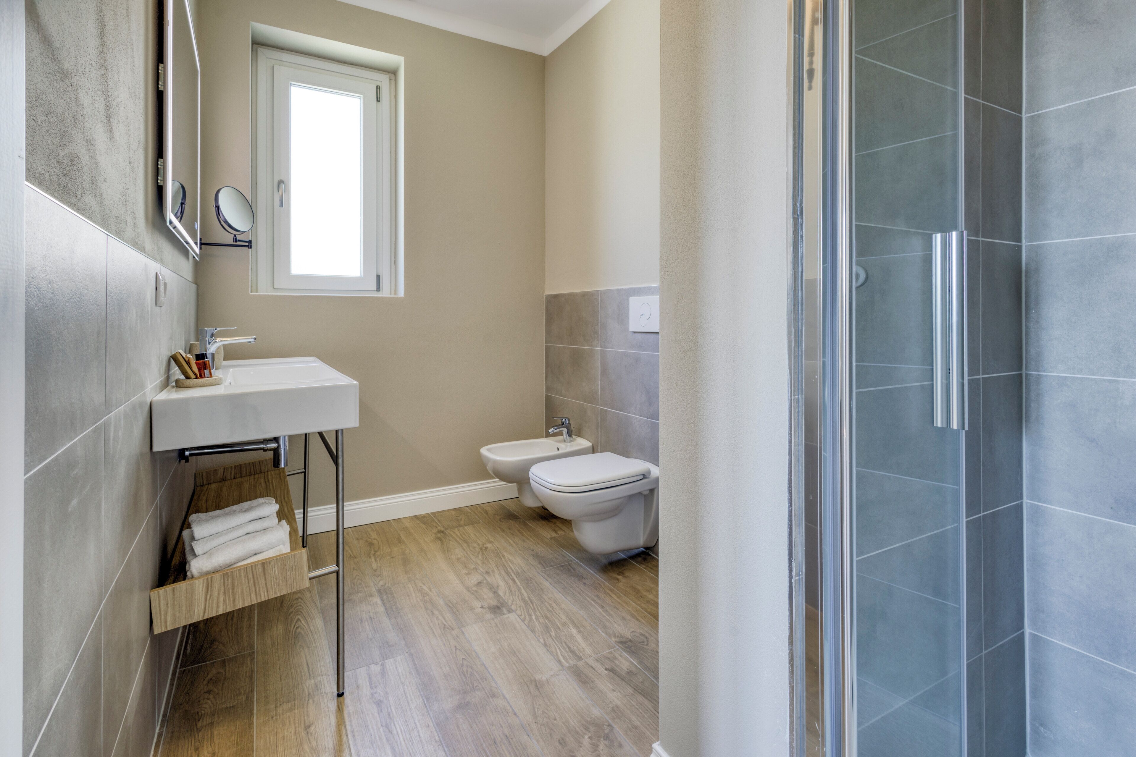 Ein Badezimmer mit Waschbecken, Spiegel, Handtuchhalter, Bidet und Dusche.