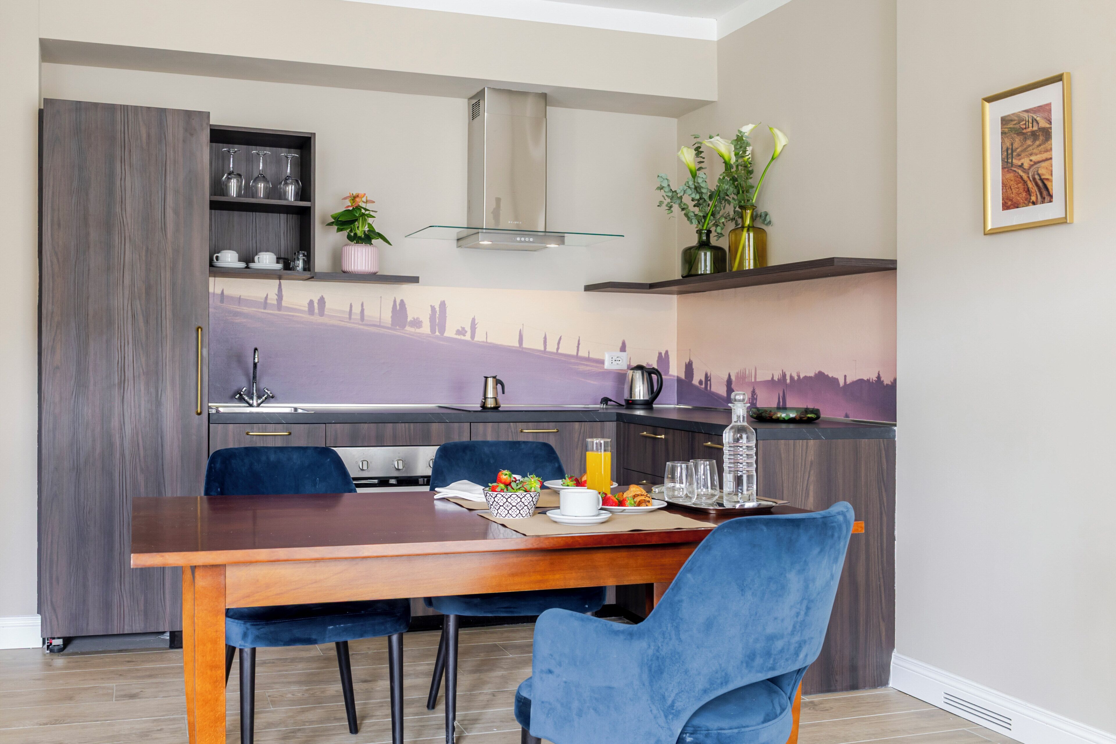 A modern kitchen with a dining table, chairs, and a decorative backsplash.