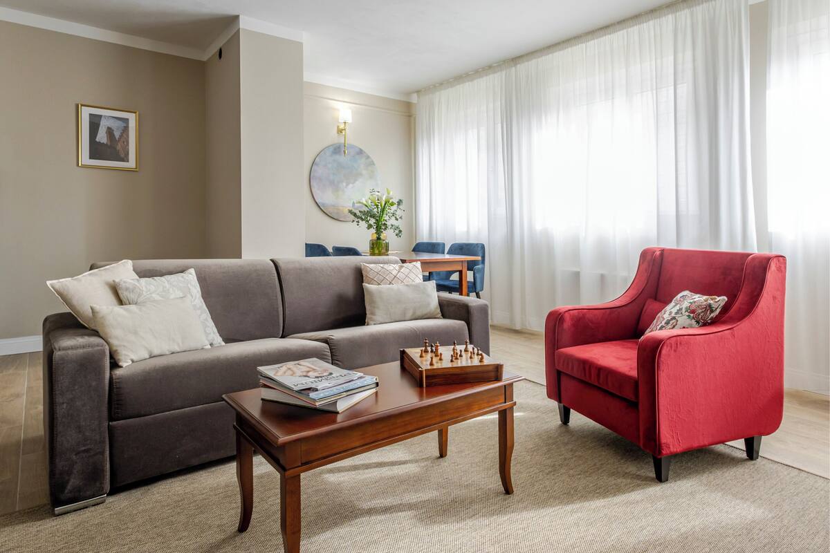 Un salon comprenant un canapé, un fauteuil, une table basse et un jeu d’échecs.