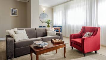 Ein Wohnzimmer mit einer Couch, einem Sessel, einem Couchtisch und einem Schachbrett.