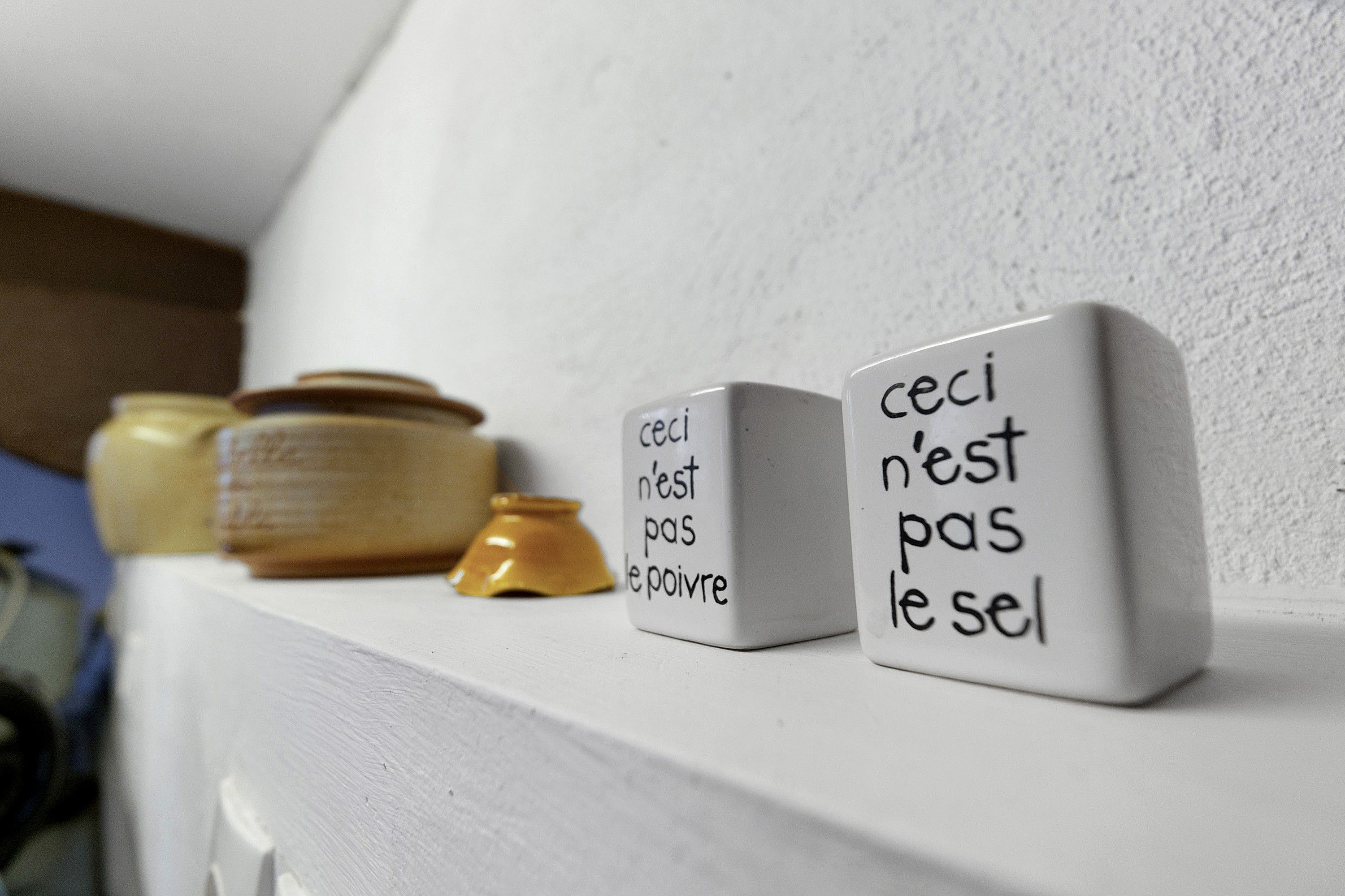 A shelf with white blocks containing French phrases.