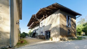 Un bâtiment à deux étages avec une allée en gravier et une clôture en bois.
