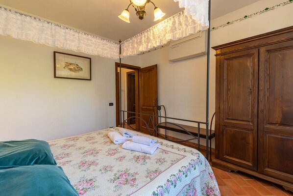 Un dormitorio con cama, armario, silla y puerta.