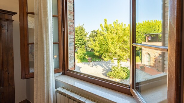Une pièce dotée d’une grande fenêtre, d’un radiateur et d’une armoire en bois.