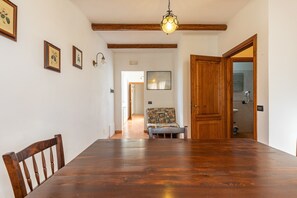 Een eetkamer met een houten tafel, stoelen en een hanglamp.