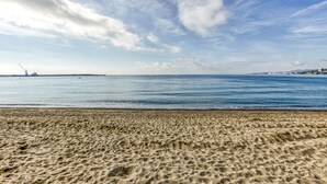 Une plage avec un ciel dégagé et une mer calme.
