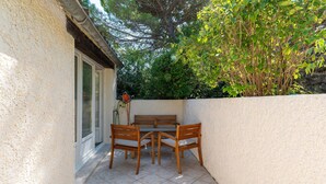 A patio with a table and chairs, a bench, and a wall with a door. - Holiday Home "Gîte Lou Barry" with Shared Pool & Wi-Fi (Mirabel-aux-Baronnies)