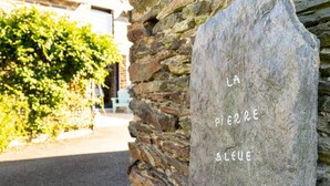 Un mur de pierres sur lequel est apposée une enseigne indiquant « LA PIERRE BLEUE » en lettres blanches.