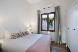 A bedroom with a bed, a nightstand, a lamp, a window with curtains, and a wardrobe. - Holiday Home 'Casa Camino La Estrella B' with Mountain View, Wi-Fi and Air Conditioning (Breña Alta)
