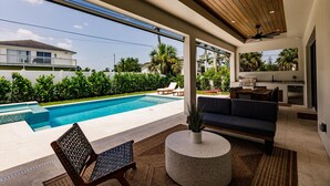 Un espacio moderno para disfrutar del aire libre, con piscina, sofá y mesa de comedor.