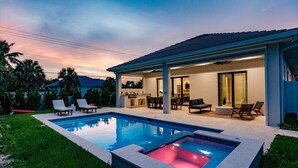 A modern house with a swimming pool, outdoor seating, and a patio area.