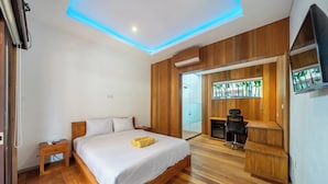 A modern bedroom with a wooden bed, bedside table, and a desk with a chair. - ZenDen (Tibubeneng)