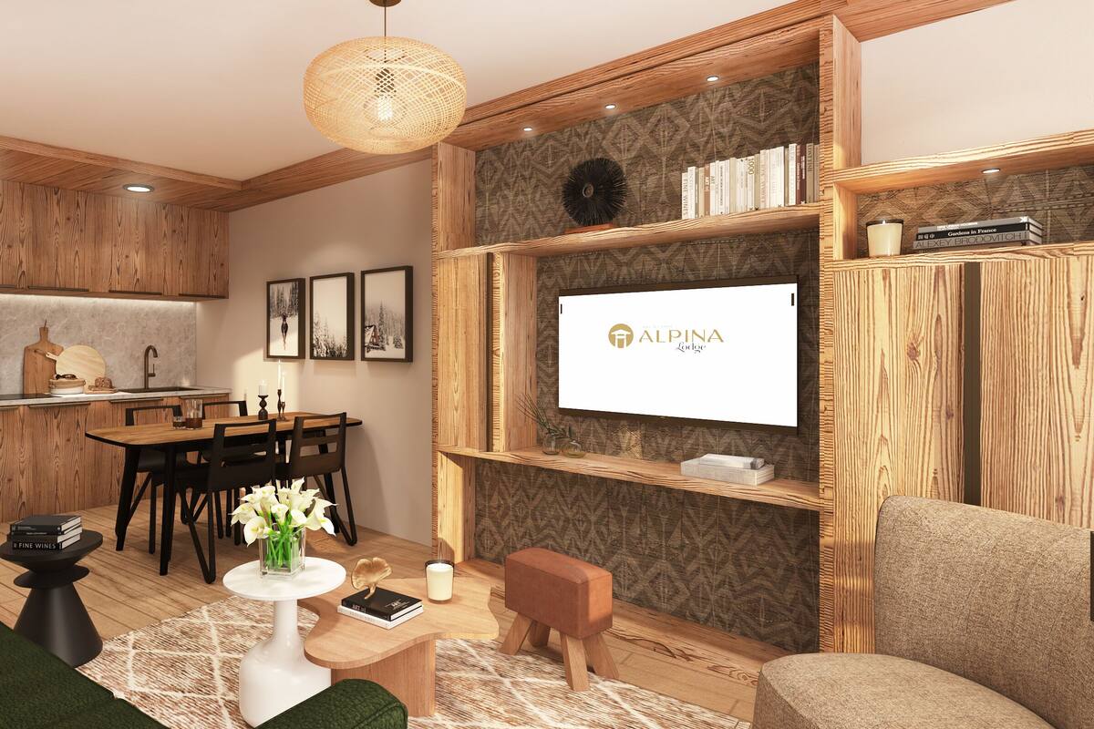 Ein modernes Wohnzimmer mit Essbereich, Holzmöbeln, einem Wand-Fernseher und einem Bücherregal.