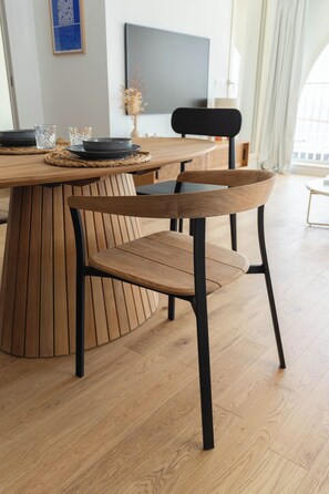 A wooden dining table with a black chair in a modern room with wooden flooring. - Porte Bleue Marseille (Marseille)