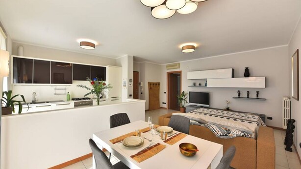 Un appartement moderne comprenant un coin repas, une cuisine et un espace de vie.