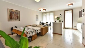 Une chambre d’hôtel moderne équipée d’un lit, d’un bureau et d’une kitchenette.