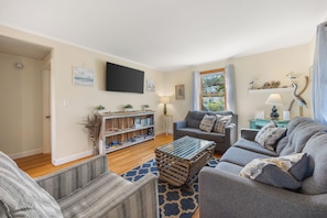 A living room with a sofa, armchairs, a coffee table, and a bookshelf.
