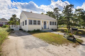 A single-story house with a front porch, a small driveway, and a mailbox.