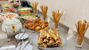 A buffet table with various food items and utensils. - AFSONA HOTEL (Bukhara)