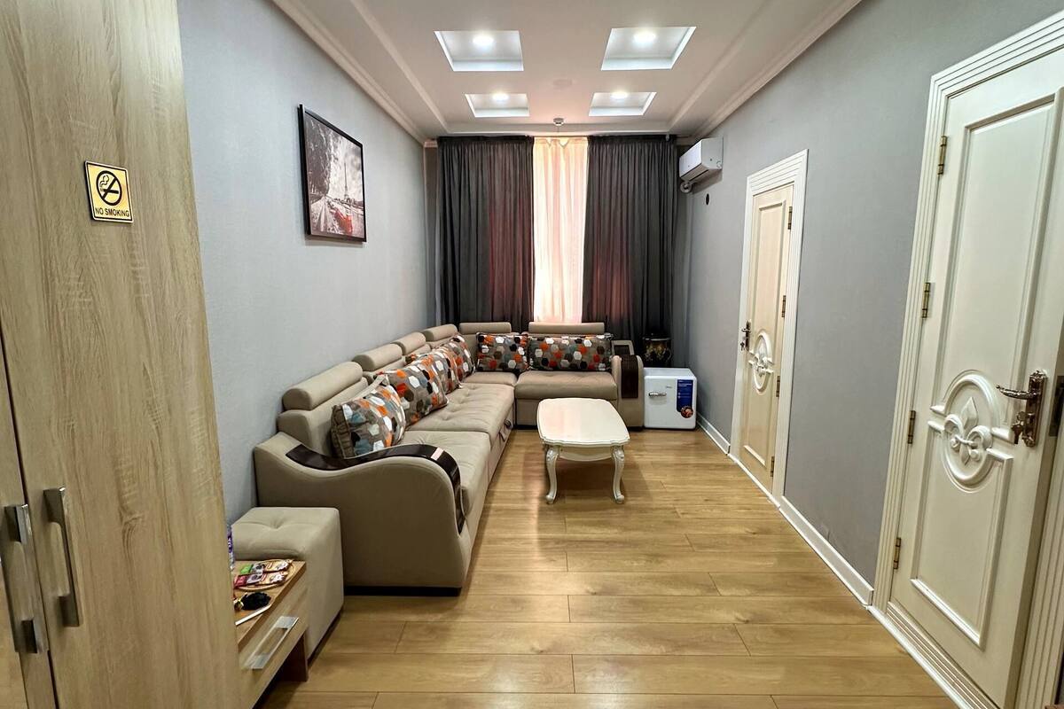 Una sala de estar con un sofá modular, una mesita y un armario.