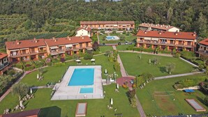 Ein großes Hotel mit mehreren Gebäuden, einem zentral gelegenen Schwimmbad und umlaufenden Grünflächen.