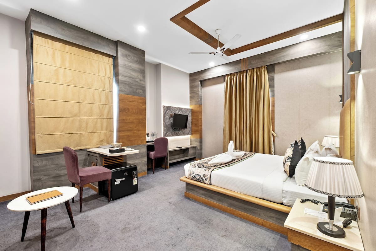 Una habitación de hotel moderna con cama, escritorio, silla y televisión.