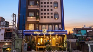 A multi-story hotel with a prominent sign reading "Hotel PrimoLand." - Primeland Hotel (Varanasi)