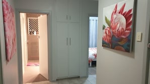 A bedroom with a bed, a wardrobe, and a bathroom visible through an open door.