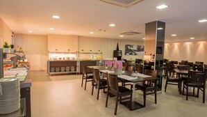 A modern dining area with multiple tables and chairs, a buffet counter with food and beverages, and a kitchen in the background. - Hotel del Pui by Nexta (La Massana)