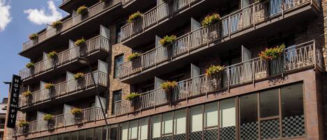 A multi-story hotel with balconies adorned with flower boxes.