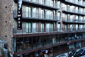 A multi-story hotel with balconies, large windows, and a stone facade. - Hotel del Pui by Nexta (La Massana)