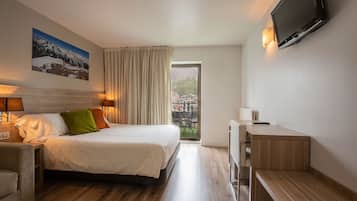 Vierpersoonskamer | Een minibar, een kluis op de kamer, een bureau, verduisterende gordijnen