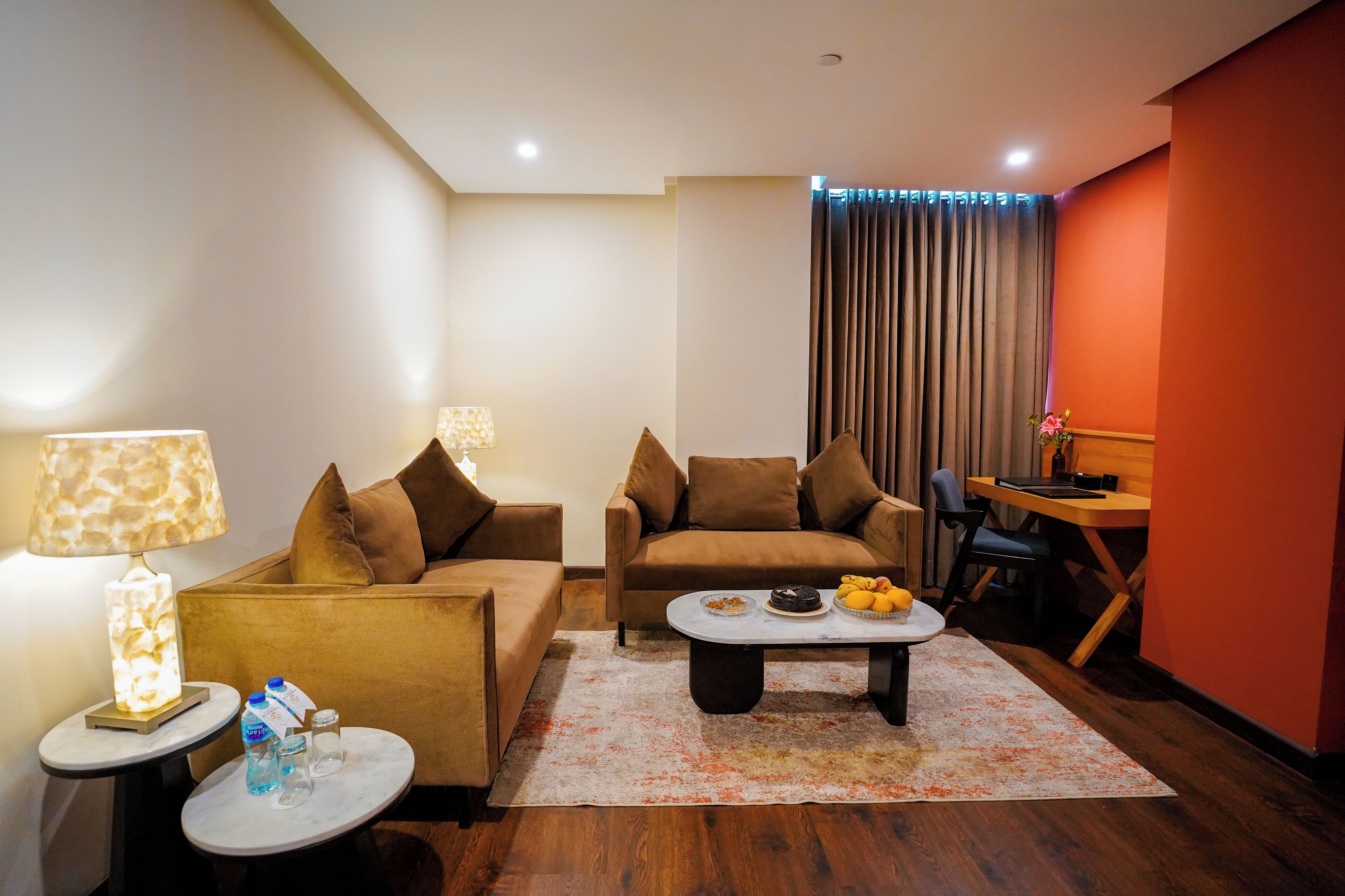 A modern living room with a sofa, a coffee table, and a dining area.