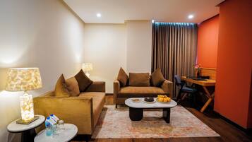 A modern living room with a sofa, a coffee table, and a dining area.