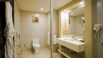 Un baño moderno con inodoro, lavamanos y ducha.