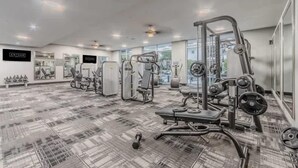 A gym with various exercise machines, a patterned floor, and large windows. - Unwind at Cityline - Premium 1BR in Dallas (Dallas)