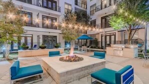An outdoor patio area with a fire pit, seating, and a bar area. - Unwind at Cityline - Premium 1BR in Dallas (Dallas)