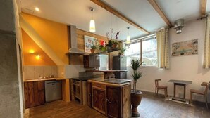 Une cuisine avec des meubles en bois, un îlot central et des plantes suspendues.