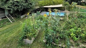 Un jardin agrémenté d’une structure en bois, d’une petite piscine et, au loin, d’une montagne.
