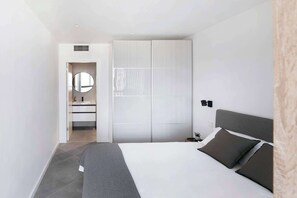A modern bedroom with a bed, bedside table, and a wardrobe.