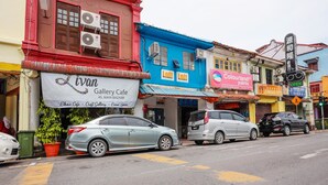 A street view with buildings housing various businesses, including a gallery cafe and a massage center. - LOFT WATERFRONT KUCHING (Kuching)