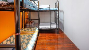 A bunk bed room with wooden flooring and a plain white wall. - LOFT WATERFRONT KUCHING (Kuching)