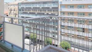 A balcony with a view of a cityscape, featuring modern buildings and a clear sky. - Allegro Boutique Apartment B (Porto)