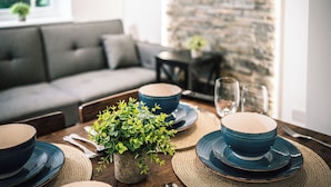 A dining table set with blue plates, bowls, and a potted plant. - Stunning 2-bed Apartment in Banbury (Banbury)