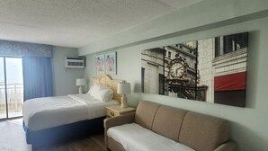 Una habitación de hotel con cama, sofá, un reloj de pared y ventana con cortinas.