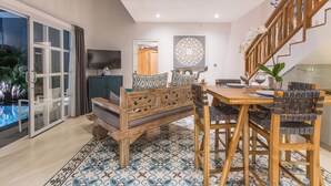 A dining area with a wooden table and chairs, a bench, and a patterned floor. - One bedroom private pool romantic villa (Bali)
